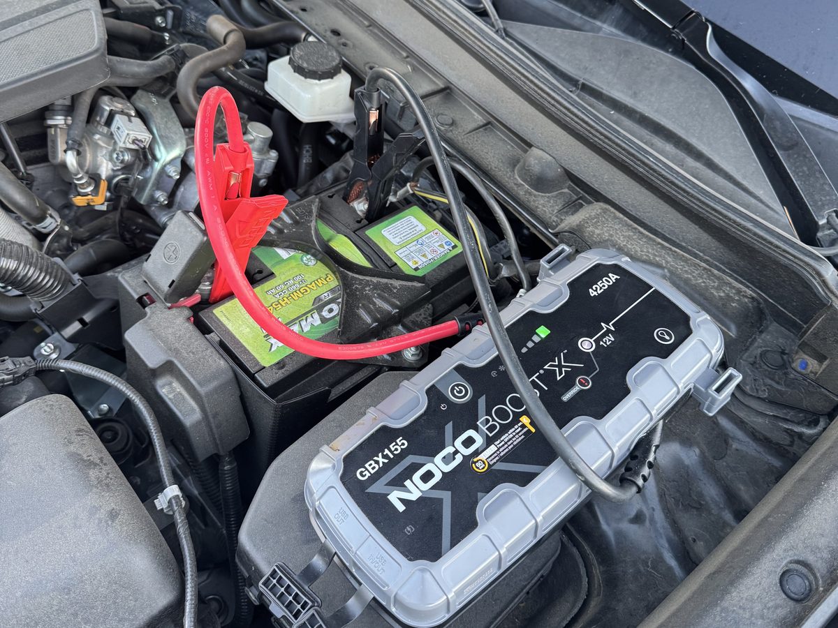 Technician jump starting a car